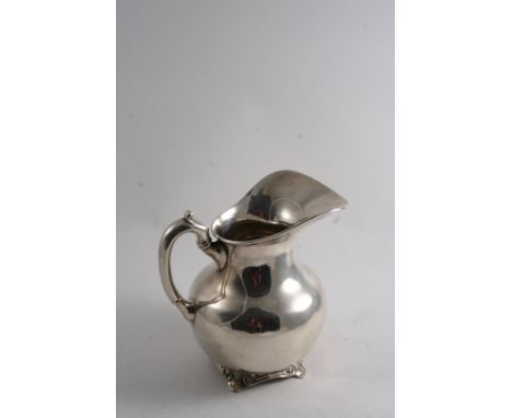 A 20TH CENTURY MEXICAN WATER PITCHER of baluster form on small scroll feet, with a scroll handle;  8.3"  (21.4 cms) high;  31