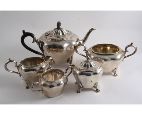 AN EDWARDIAN TEA POT, CREAM JUG, SUGAR BOWL, LARGE SUGAR BOWL & A TEA CADDY each of a similar design but non-matching, scroll