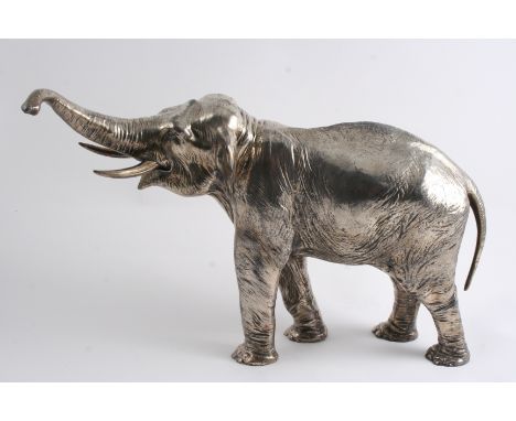 A LATE 19TH CENTURY PLATED CAST FIGURE OF AN INDIAN BULL ELEPHANT with his trunk raised, traces of a mark on one foot, probab