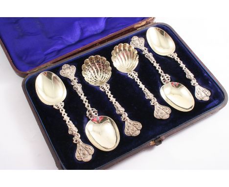 A VICTORIAN CASED SET OF FOUR PARCELGILT FRUIT SPOONS, a sugar sifter ladle & a cream ladle with decorative cast stems, crest