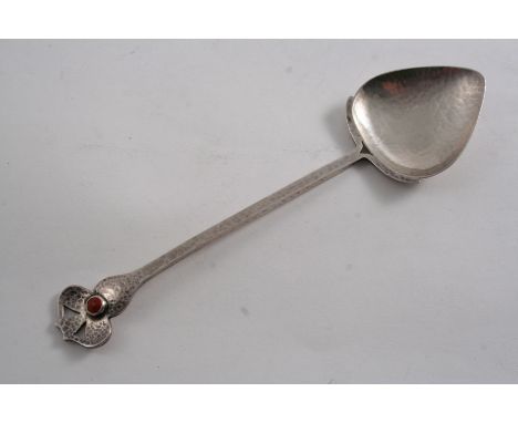AN EDWARDIAN ART NOUVEAU SPOON with a hammered finish & a shaped and pierced terminal, set with a coloured boss, by A.E. Jone