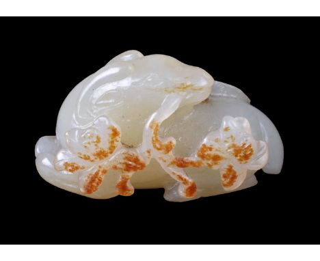 A Chinese white and russet jade ‘ram’ carving, 18th or 19th century, Qing Dynasty, the recumbent ram with its head turning ba