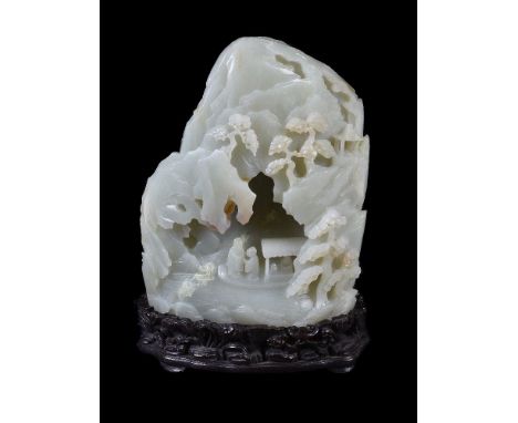 A Chinese pale celadon and russet boulder carving, 19th or 20th century, the boulder is carved to one side with a mountainous