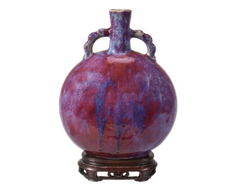 A Chinese flambé glazed two-handled moon flask, Qing Dynasty, covered in a brilliant mottled purplish-red glaze with extensiv