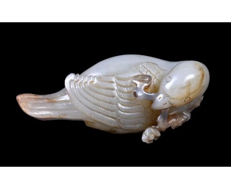 A Chinese celadon and russet jade carving of a Magpie, Qing-Republican Dynasty, probably 19th century, with white inclusions,