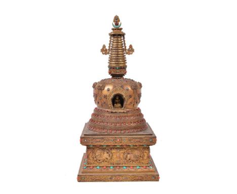 ϒA gilt-bronze Buddhist stupa, probably Nepal, 20th century, of bell-shaped form, on square raised pedestal, the tapered fini