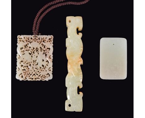 A Chinese celadon and russet jade plaque, pierced in openwork with two boys and chillong amid an interwoven pattern of foliag