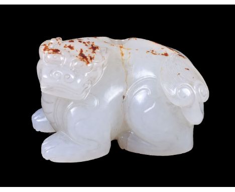 A Chinese white jade or pale celadon and russet carving of a lion, possibly Qing Dynasty, 19th century, with incised details 
