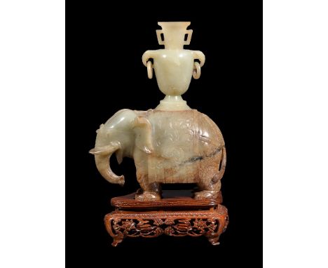 A Chinese celadon and russet jade 'Elephant', Qing Dynasty, 19th century, standing four square with carved foliage on the on 