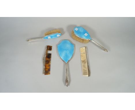 A silver and mostly blue enamelled four piece lady's part dressing set, comprising; a hand mirror, a hairbrush, a small hairb