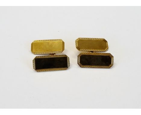 A pair of 9ct gold, cut cornered rectangular cufflinks, the backs and the fronts plain to the centres, within engine turned b