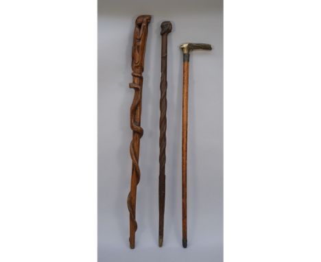 An African hard wood walking stick, relief carved with a wild cat pommel and cobra to the shaft, 93cm, an African walking sti