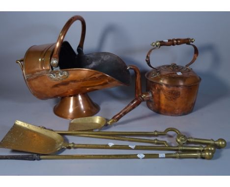 A 19th century copper helmet shaped coal scuttle, a large kettle and a set of brass fire tools, (5). 