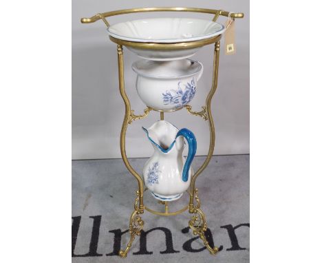 A Victorian style brass three tier washstand, 43cm wide x 92cm tall, with three ceramic bowls and a jug.