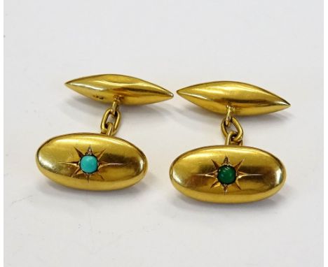 A pair of gold and turquoise set cufflinks, each oval front star set with a circular turquoise and with torpedo shaped backs,