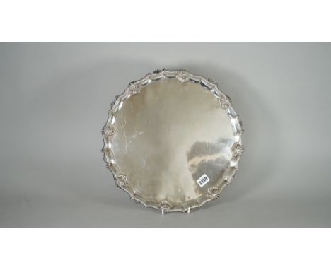 A George III silver salver, of shaped circular form, with a pie-crust rim in the Chippendale style, having scalloped motifs a