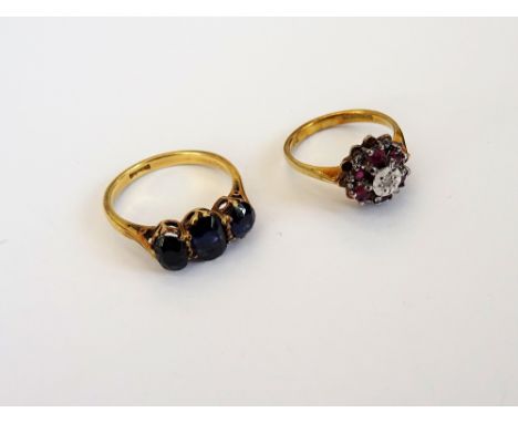 A 9ct gold, ruby and diamond set seven stone cluster ring, mounted with a circular cut diamond at the centre, in a surround o