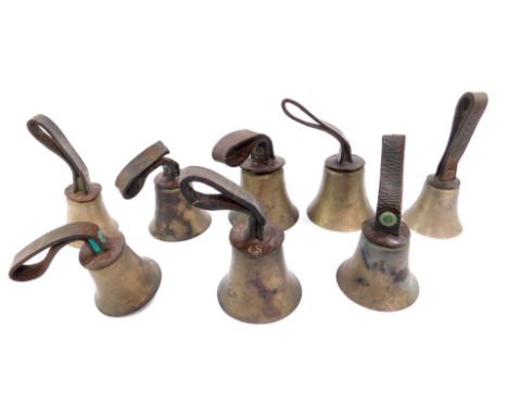 Eight hand bells, two bearing hammers, with leather handles inscribed with initials G S.