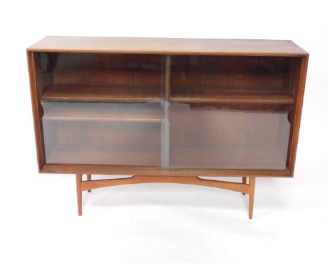 A Dalescraft 1960's teak bookcase, of rectangular section, with two glazed doors opening to reveal three shelves, raised on t