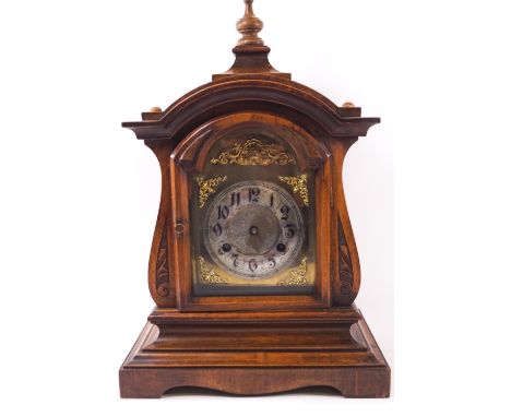 A walnut cased mantel clock, the domed top set a turned finial over a brass spandrelled dial with an Arabic chapter ring on a