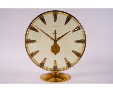 A round brass cased manual wind skeleton movement Jaeger Lecoultre clock with crystal chapter indicators on a plain domed foo