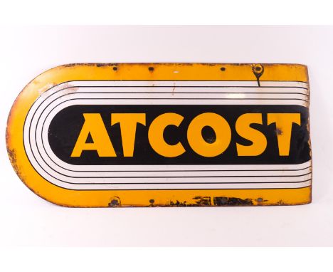 An enamel sign in yellow and black for 'ATCOST', 30cm x 64cm