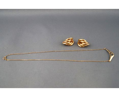 A selection of two yellow metal jewellery items to include a pair of half hoop tube stud earrings and a centrepiece pendant n