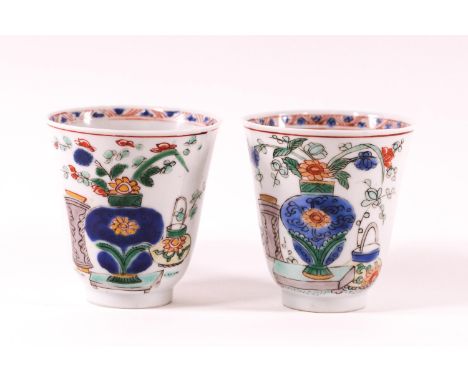 A pair of Chinese export porcelain Kangxi period wine cups(1654-1722) with later Dutch decoration of vases with flowers in po