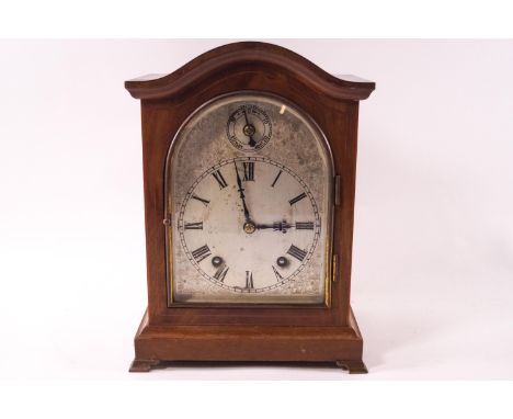 A W &amp; H mahogany cased eight day mantel clock, the arched dial with fast/slow dial, the movement striking on a gong, stam