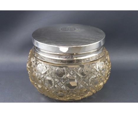 A cut glass dressing jar with silver lid, the bellied body with a variant of hobnail cutting, the pull off lid with parallel 