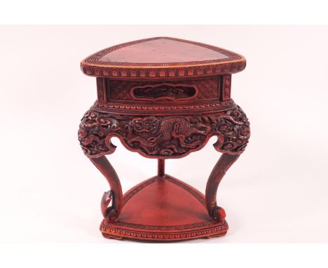 A cinnabar tripod stand carved with dragons, 17cm high