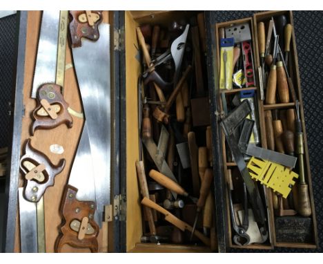A box of tools including saws, wooden planes, measures, etc.
