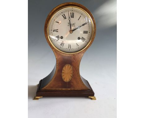A Comitti London balloon shaped clock on bracket feet. Height 30cm.
