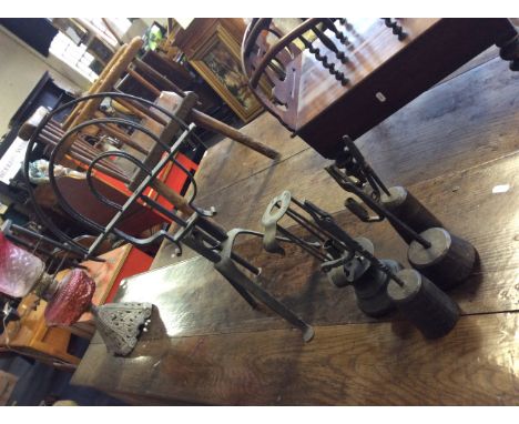 Three handforged wick stands on wooden bases, with an adjustable candlestick holder and a revolving stand on tripod base.
