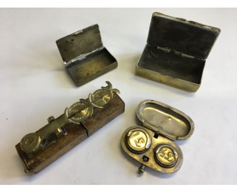 A set of small brass sovereign scales, a coin holder, and two pill boxes.