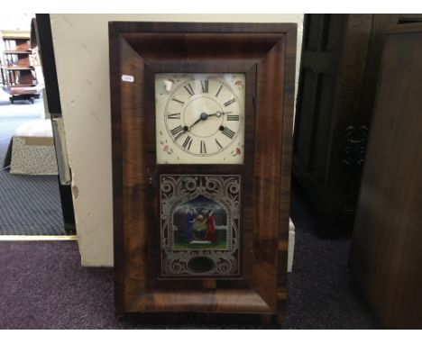 A mahogany framed wall clock with rosewood band and decorated glass panel.
