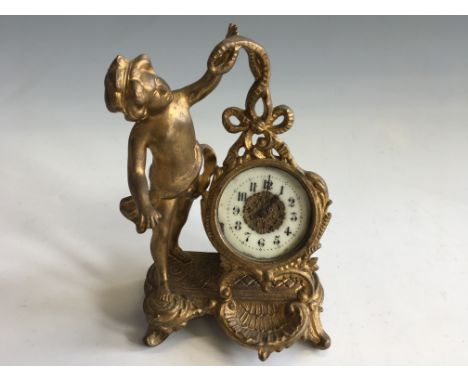 A small gold painted clock with cherub decoration.
