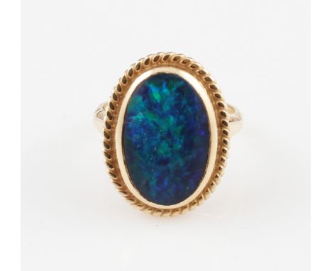 A 9ct yellow gold black opal doublet ring, set with an oval black opal doublet cabochon, measuring approx. 18x12mm, with rope