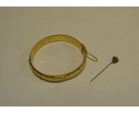 A 9ct gold hollow hinge bangle, Chester 1958, 19.3g gross;  a diamond set shield top 15 ct gold tie pin, stamped 15ct, 1.1g g