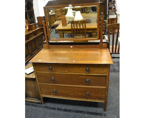 An early-20th century light oak dressing chest, rectangular mirror, the projecting base with two short above two long drawers