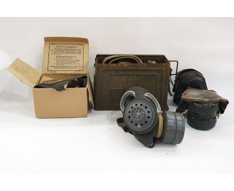 Three assorted gas masks, belts and ammunition tin 