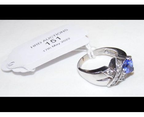 A 14k ring with crossed diamonds and triangular blue stone