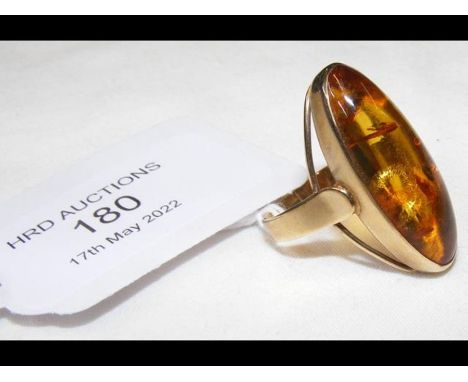 A gold ring with elliptical amber 