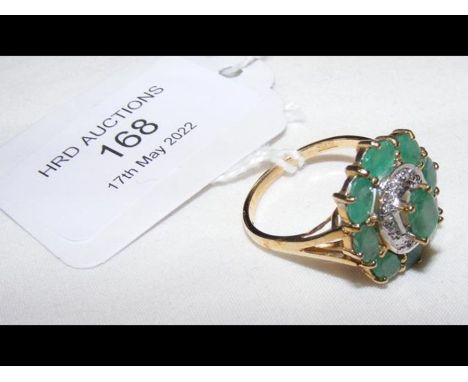 A 9ct gold ring set with diamonds and emeralds