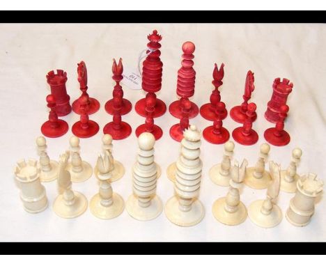 A 19th century 'Barley Corn' pattern ivory chess set with natural and red stained pieces - complete with some damage 