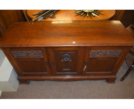 A late Victorian walnut sideboard, with Art Nouveau carved decoration to three panel doors, raised on bracket feet, 150cms wi