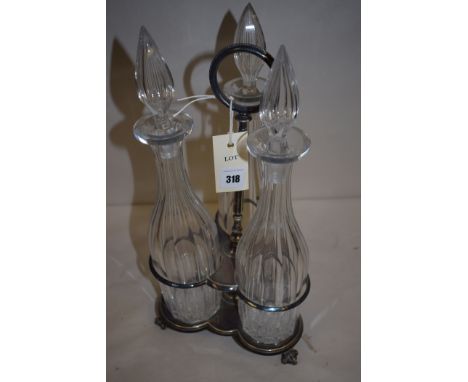 A silver plated triform decanter stand, with three cut glass decanters with teardrop shaped stoppers.