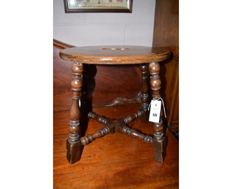A 19th Century oak oval stool, the turned legs joined by X-shaped stretchers.