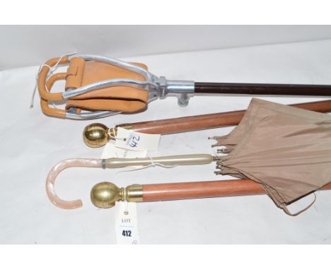 A shooting stick by Mills, Birmingham; two modern walking canes; and a parasol.  (4)