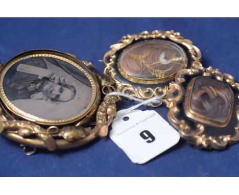 Two Victorian yellow metal mourning brooches, with plaited hair panels and black enamel decoration, inscription to one; and a